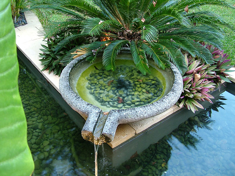 Cultivart water feature in tropical garden nedlands with lavastone bowl overflowing to pond