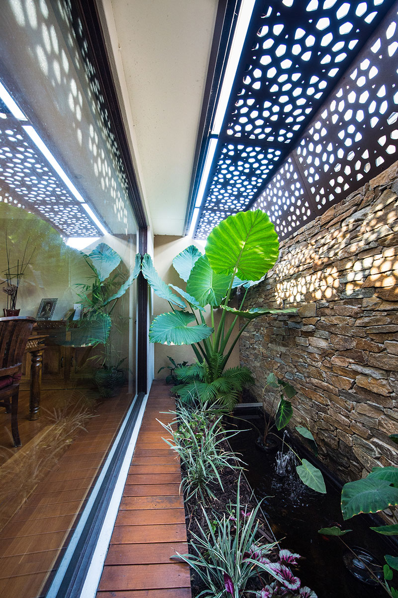 dining room atrium with laser cut roof and stone wall water feature