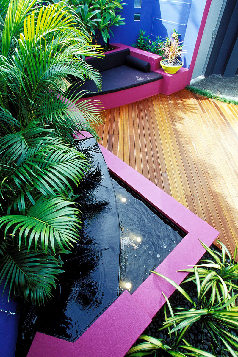 bright pink courtyard with blue walls and tropical plants