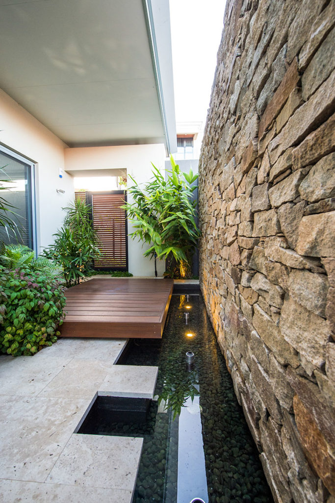 bathroom courtyard with water feature and yoga platform and beautiful stone wall